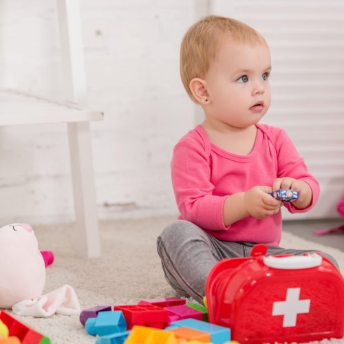 adorable child playing with first aid kit in children room